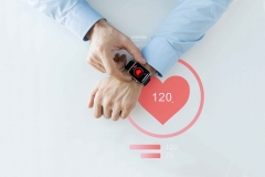 close up of hands with heart icon on smart watch