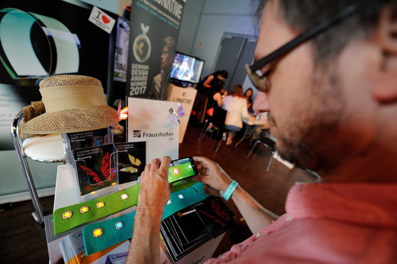 Jan Hesse (Fraunhofer FEP) demoing organic LEDs at the Exhibition Hall at the Wear It Festival - The Conference on Wearables, fashion tech, smart clothing and consumer innovation on 19-20 June 2018 at the Kulturbrauerei Berlin - (c) Wear It Berlin / Michael Wittig, Berlin